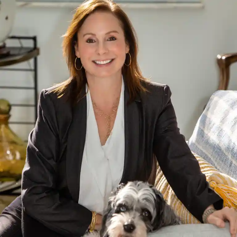Andrea L. Jakob seated in a welcoming office setting with her dog